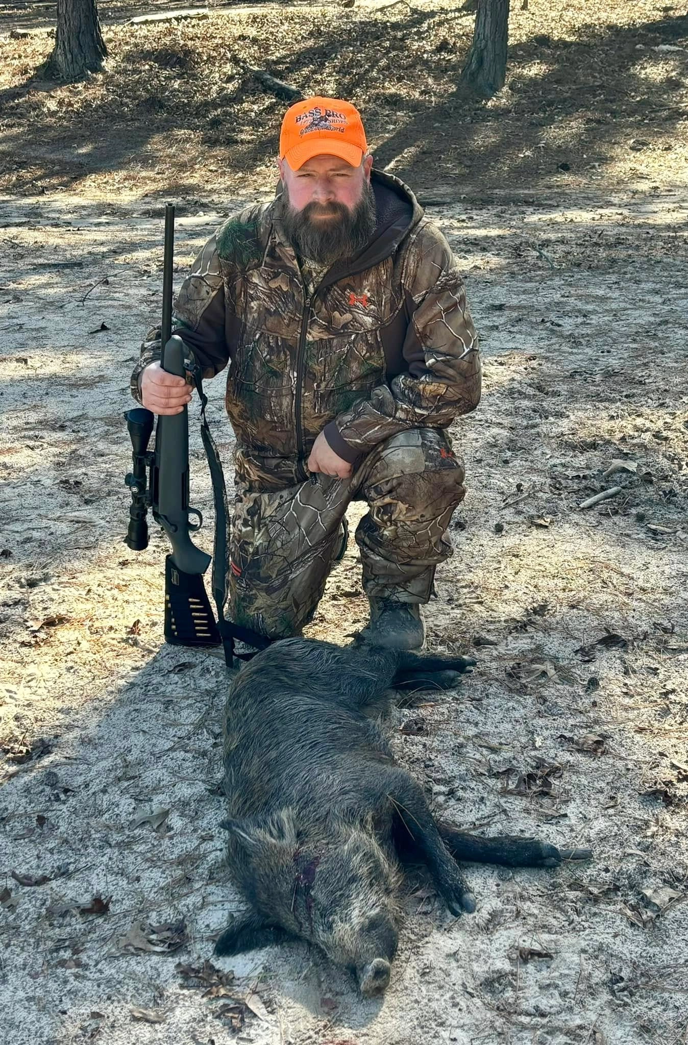 A hunter with a harvested hog at Boggy Creek Outfitters in Bivins, Texas